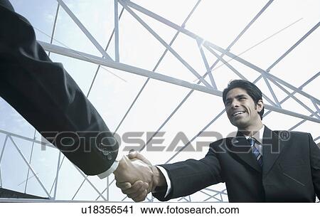 Low angle view two businessmen shaking hands at a construction site View Large Photo Image Stock Image - Low angle view two businessmen shaking hands at a construction site. Fotosearch