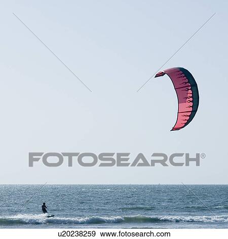 Stock Photo - Man parasailing in the sea, Morjim Beach, Goa, India. Fotosearch