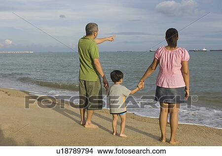 Picture - Mid adult couple with their son on the beach. Fotosearch