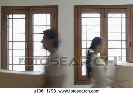 Mid adult man and a young woman carrying boxes View Large Photo Image Stock Image - Mid adult man and a young woman carrying boxes. Fotosearch
