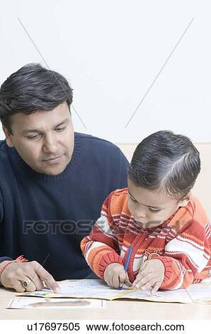 Stock Photography - Mid adult man teaching his son to draw. Fotosearch