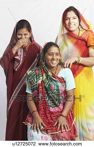 Mid adult woman sitting and two young women standing behind her View Large Photo Image Stock Image - Mid adult woman sitting and two young women standing behind her. Fotosearch