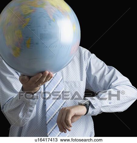 Mid section view of a businessman holding a spinning globe and checking the time View Large Photo Image Stock Image - Mid section view of a businessman holding a spinning globe and checking the time. Fotosearch