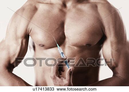 Mid section view of a man holding a syringe against his chest View Large Photo Image Stock Image - Mid section view of a man holding a syringe against his chest. Fotosearch