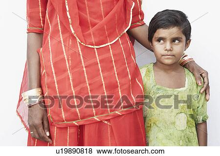 Stock Photo - Mid section view of a woman standing with her daughter. Fotosearch