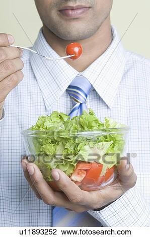 Mid section view of a young man holding a bowl of salad View Large Photo Image Stock Image - Mid section view of a young man holding a bowl of salad. Fotosearch
