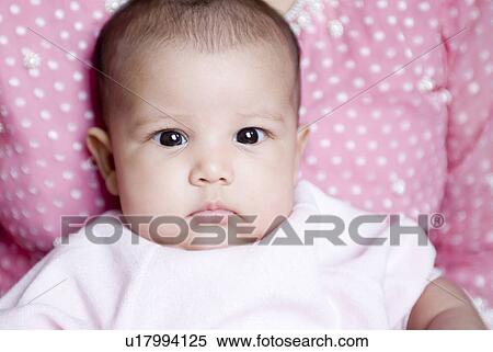 Stock Photography - Portrait of a baby girl with her mother in the background. Fotosearch