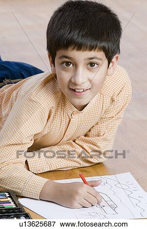 Stock Photo - Portrait of a boy drawing with a color pencil. Fotosearch
