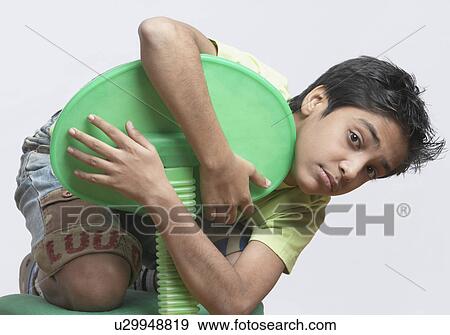 Portrait of a boy holding a chair View Large Photo Image Stock Photo - Portrait of a boy holding a chair. Fotosearch