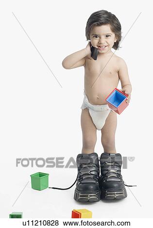 Portrait of a boy holding a mobile phone and smiling View Large Photo Image Stock Photo - Portrait of a boy holding a mobile phone and smiling. Fotosearch