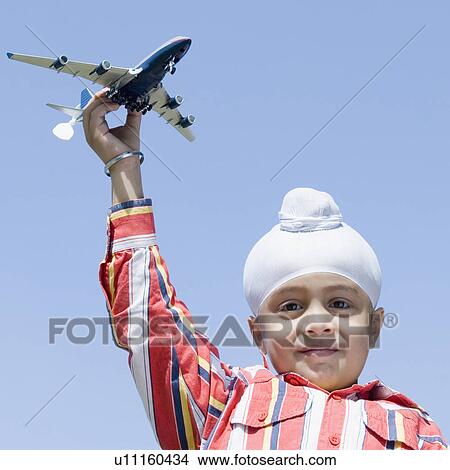 Picture - Portrait of a boy holding a model airplane and smiling. Fotosearch