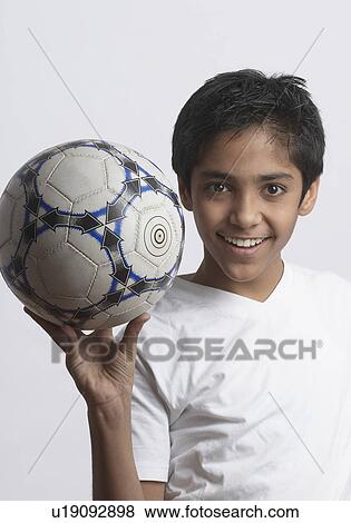 Stock Photo - Portrait of a boy holding a soccer ball. Fotosearch