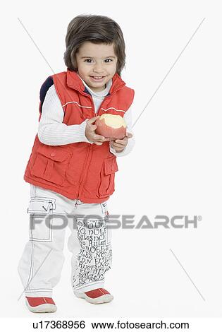 Stock Photograph - Portrait of a boy holding an apple and smiling. Fotosearch