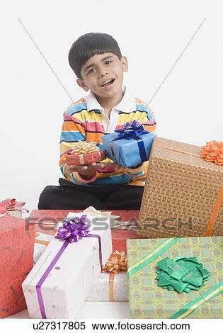 Portrait of a boy holding gifts View Large Photo Image Stock Photography - Portrait of a boy holding gifts. Fotosearch