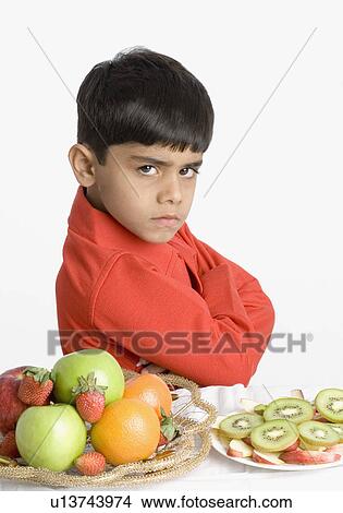 Portrait of a boy looking angry at a breakfast table View Large Photo Image Picture - Portrait of a boy looking angry at a breakfast table. Fotosearch