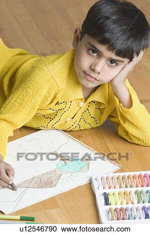 Portrait of a boy lying on the hardwood floor and drawing with crayon View Large Photo Image Stock Image - Portrait of a boy lying on the hardwood floor and drawing with crayon. Fotosearch