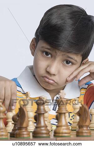 Stock Photo - Portrait of a boy playing chess. Fotosearch