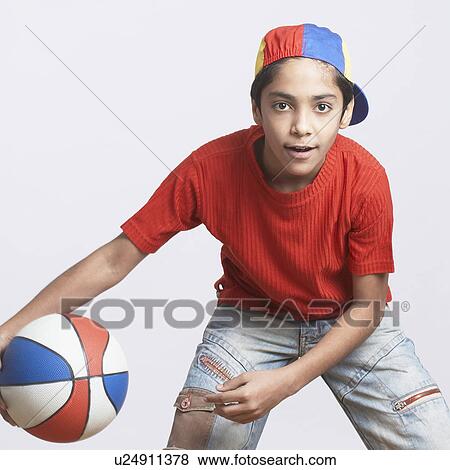 Stock Photo - Portrait of a boy playing with a basketball. Fotosearch