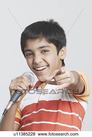 Portrait of a boy singing in front of a microphone View Large Photo Image Stock Photo - Portrait of a boy singing in front of a microphone. Fotosearch