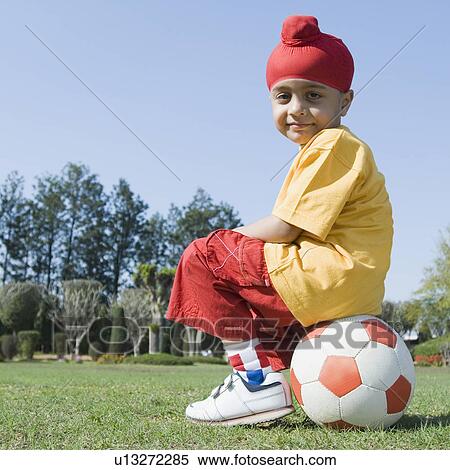 Portrait of a boy sitting on a soccer ball View Large Photo Image Stock Photography - Portrait of a boy sitting on a soccer ball. Fotosearch