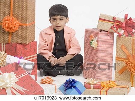 Portrait of a boy sitting with a stack of presents View Large Photo Image Stock Image - Portrait of a boy sitting with a stack of presents. Fotosearch
