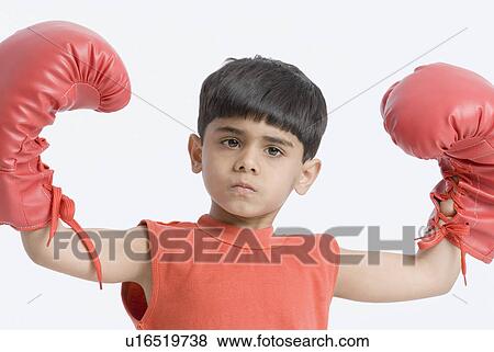 Stock Photo - Portrait of a boy wearing boxing gloves and flexing his muscles. Fotosearch