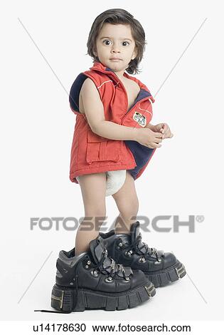 Portrait of a boy wearing oversized hiking boots View Large Photo Image Stock Image - Portrait of a boy wearing oversized hiking boots. Fotosearch