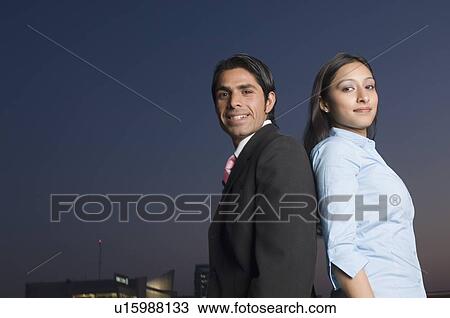 Portrait of a businessman and a businesswoman standing back to back View Large Photo Image Stock Image - Portrait of a businessman and a businesswoman standing back to back. Fotosearch
