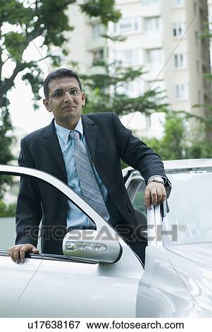 Stock Photo - Portrait of a businessman getting into his car. Fotosearch