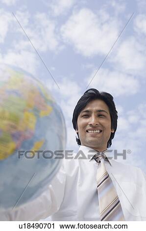 Portrait of a businessman holding a globe and smiling View Large Photo Image Stock Image - Portrait of a businessman holding a globe and smiling. Fotosearch