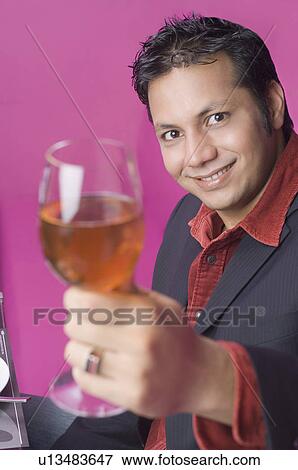 Portrait of a businessman holding a wine glass View Large Photo Image Stock Photo - Portrait of a businessman holding a wine glass. Fotosearch