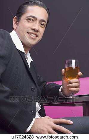 Stock Photo - Portrait of a businessman holding a glass of wine. Fotosearch
