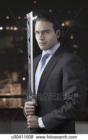 Stock Photo - Portrait of a businessman holding a machete. Fotosearch