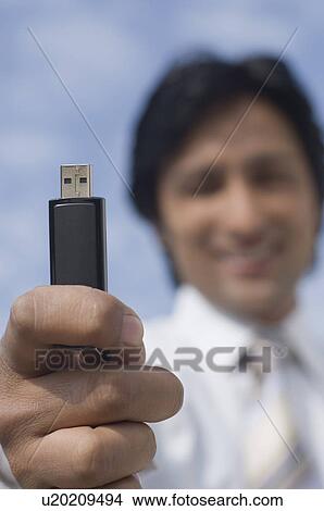 Picture - Portrait of a businessman holding a USB pen drive. Fotosearch
