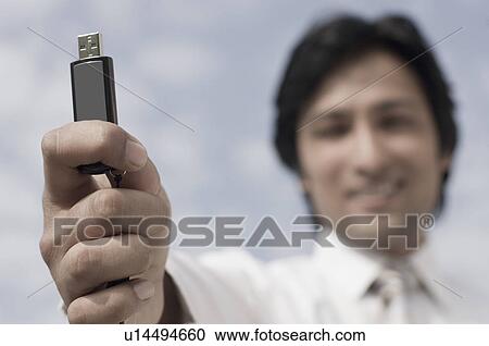 Portrait of a businessman holding a USB pen drive View Large Photo Image Stock Image - Portrait of a businessman holding a USB pen drive. Fotosearch