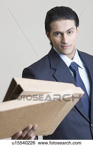 Portrait of a businessman holding files View Large Photo Image Stock Photograph - Portrait of a businessman holding files. Fotosearch