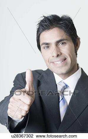 Portrait of a businessman showing a thumbs up sign and smiling View Large Photo Image Stock Image - Portrait of a businessman showing a thumbs up sign and smiling. Fotosearch