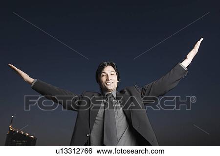 Portrait of a businessman smiling with his arm outstretched View Large Photo Image Stock Photograph - Portrait of a businessman smiling with his arm outstretched. Fotosearch
