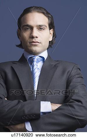 Stock Image - Portrait of a businessman standing with his arms crossed. Fotosearch