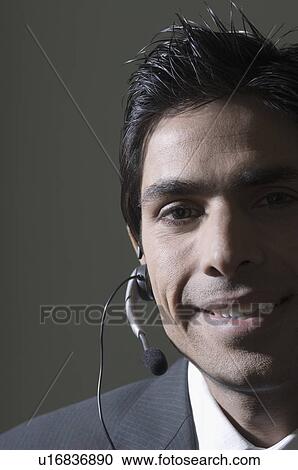 Stock Image - Portrait of a businessman wearing a headset. Fotosearch