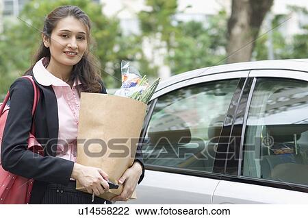 Portrait of a businesswoman holding a paper bag View Large Photo Image Stock Image - Portrait of a businesswoman holding a paper bag. Fotosearch