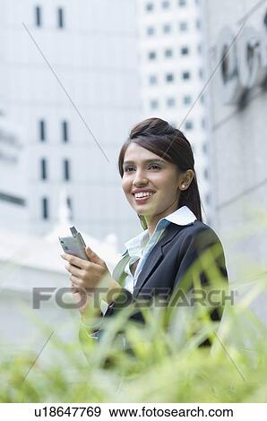 Stock Photo - Portrait of a businesswoman holding a personal data assistant. Fotosearch