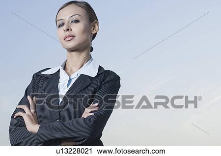 Portrait of a businesswoman standing with her arms crossed View Large Photo Image Stock Image - Portrait of a businesswoman standing with her arms crossed. Fotosearch
