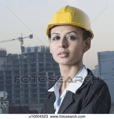 Stock Image - Portrait of a businesswoman wearing a hardhat. Fotosearch