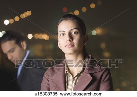 Stock Photography - Portrait of a businesswoman with a businessman in the background. Fotosearch