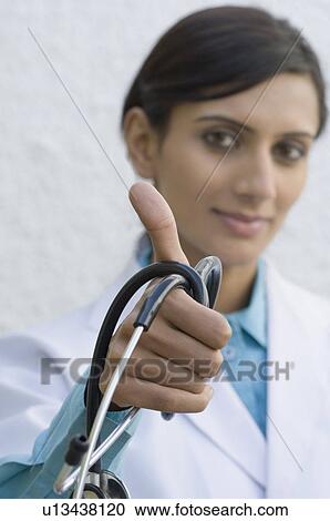 Stock Image - Portrait of a female doctor holding a stethoscope. Fotosearch