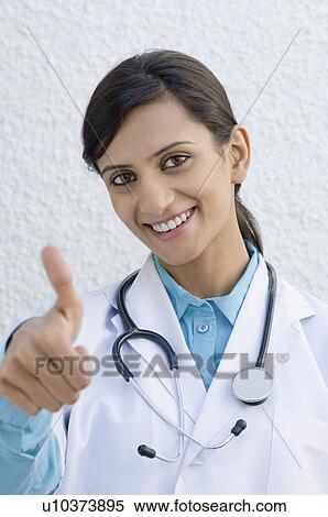 Stock Photography - Portrait of a female doctor making a thumbs up sign. Fotosearch