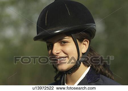 Stock Image - Portrait of a female jockey smiling. Fotosearch