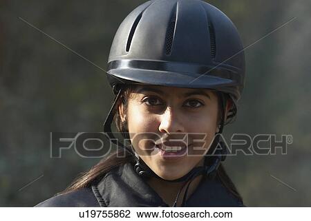 Stock Image - Portrait of a female jockey smiling. Fotosearch