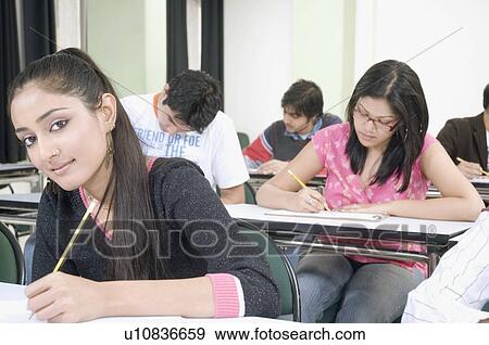 Stock Photo - Portrait of a female student sitting in a college classroom. Fotosearch